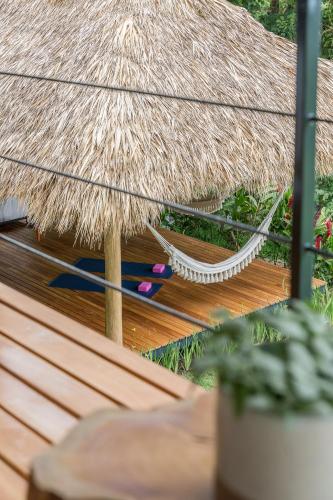 a straw umbrella on a wooden deck with a plant at Casa Mirame in Carmen