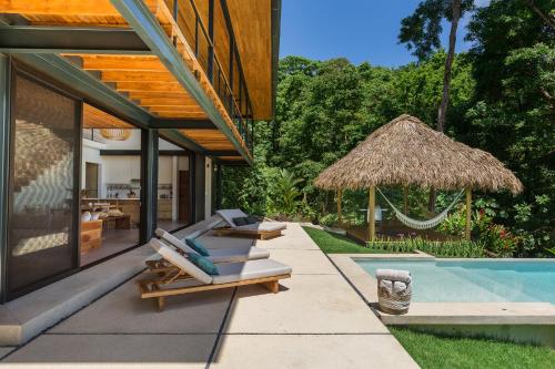 a pool with lounge chairs next to a house at Casa Mirame in Carmen