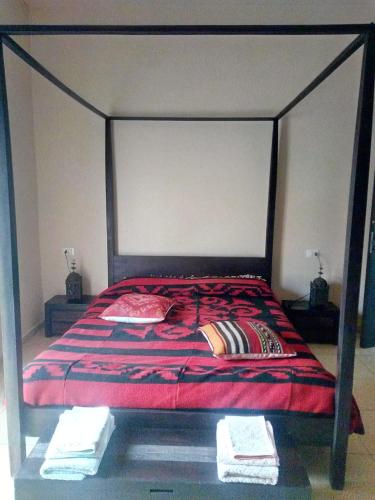 a bed with a red comforter and pillows on it at Affittacamere Appartamento colorato in Ferrara