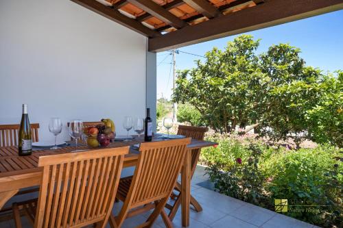 a patio with a table with wine glasses on it at Tilli'n'Joe's Nature House in Moita dos Ferreiros
