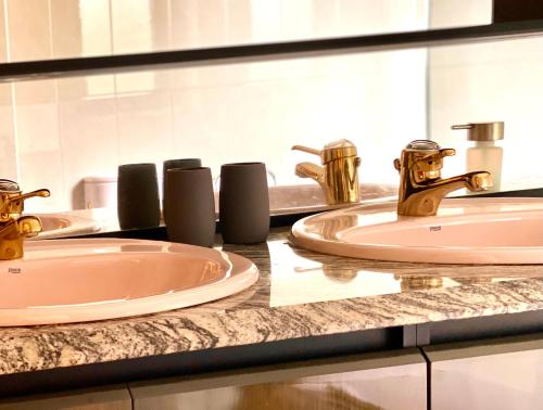 a bathroom counter with two sinks and a mirror at Housing León Casa con Jardín in León