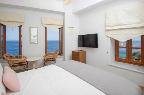 een slaapkamer met een bed en uitzicht op de oceaan bij Arion Syros in Ermoupoli