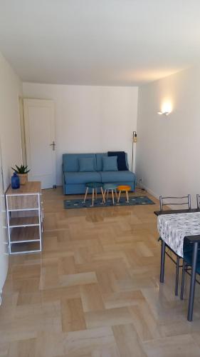 a living room with a blue couch and a table at Résidence Le Bonaparte in Roquebrune-Cap-Martin