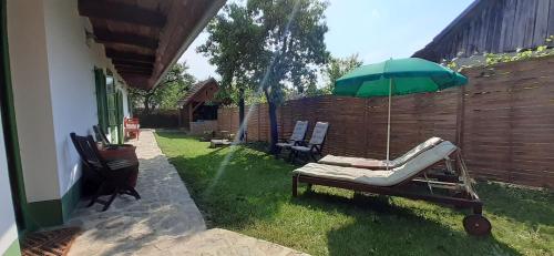 a chair and an umbrella in a yard at Padláskincsek Vendégház in Nagybörzsöny