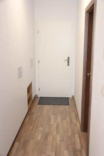 an empty hallway with white walls and wood floors at APARTMÁN K2 Zuberec in Zuberec