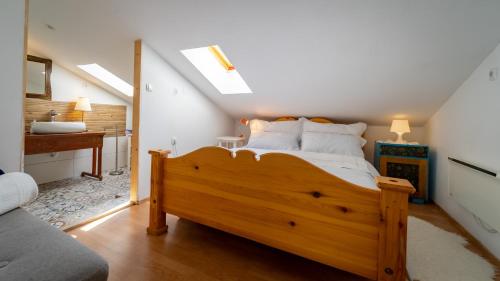 1 dormitorio con cama de madera y lavamanos en Apartment Ernestova hiša en Lokve