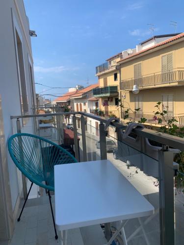 a white table and chair on a balcony with buildings at I Venti in Brucoli