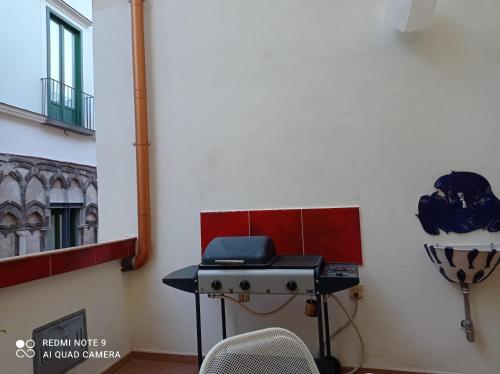 eine Küche mit einem Herd und einem Stuhl in einem Zimmer in der Unterkunft Haripergo Apartments in Salerno