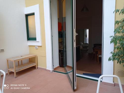 una porta a vetri che conduce a una camera con tavolo di Haripergo Apartments a Salerno