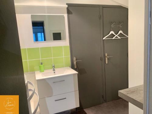 een badkamer met een wastafel, een spiegel en een deur bij ~~ LE DESCELIERS ~~ Centre Dieppe in Dieppe
