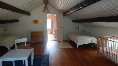 a bedroom with two beds and a wooden floor at Året runt i väldigt härlig natur Bo på lantgård in Rimforsa