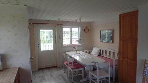 Habitación con mesa, mesa y sillas. en Året runt i väldigt härlig natur Bo på lantgård en Rimforsa