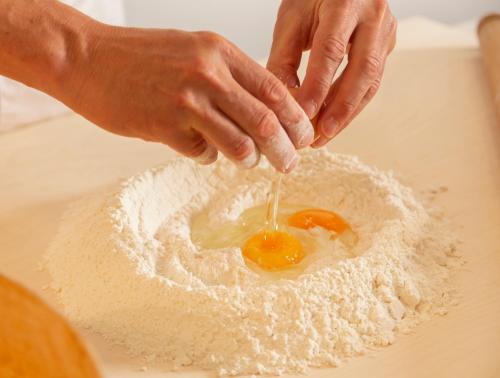 a person is mixing an egg in the flour at Hotel Cristallo in Riccione