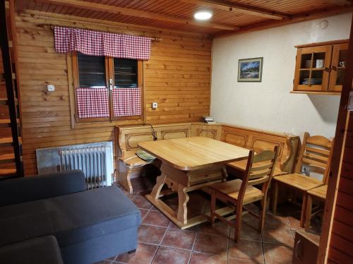 a dining room with a wooden table and chairs at Brunarica 6A - Smučišče Trije Kralji in Oplotnica