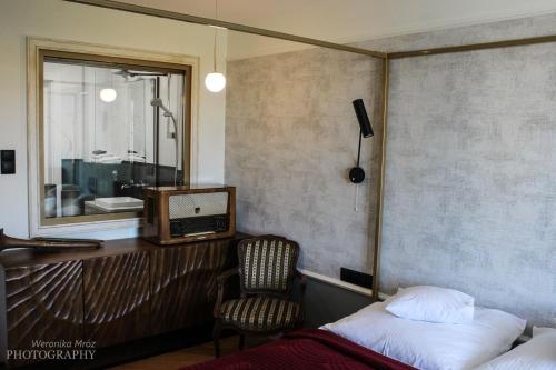 a bedroom with a bed and a tv and a chair at D Apartments "Z wizytą u Branickich" in Białystok