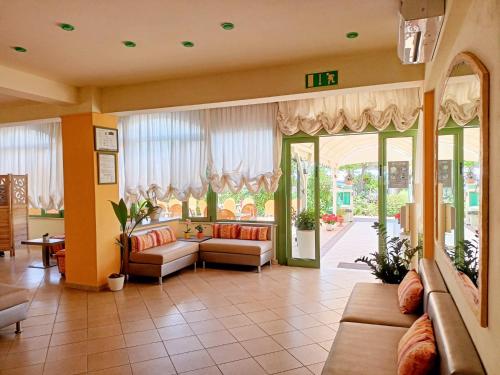 a living room with couches and a large window at Costa del Sole Only Room in Milano Marittima