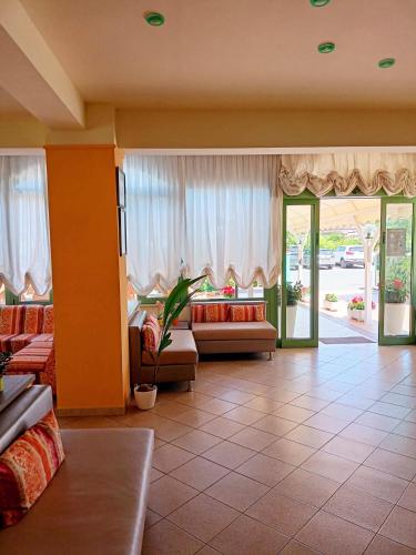 a living room with two couches and a large window at Costa del Sole Only Room in Milano Marittima