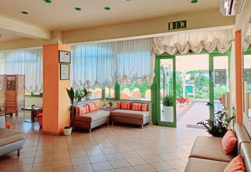 a living room with couches and a large glass door at Costa del Sole Only Room in Milano Marittima