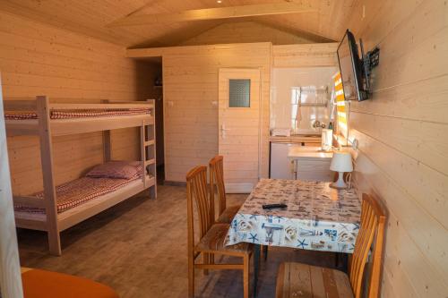 a room with a table and a bunk bed at Ośrodek Madamaku in Sianozety