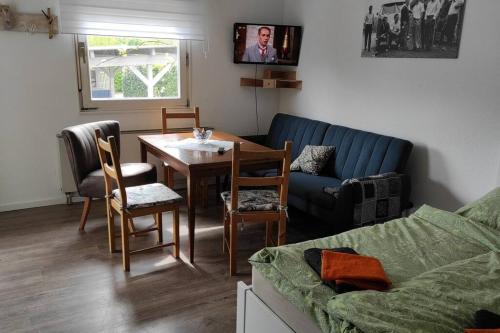 ein Wohnzimmer mit einem Tisch und einem blauen Sofa in der Unterkunft FeWo Johan - ideal für 1-2 Personen, eigene Terrasse in Hamm