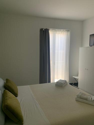 a bedroom with a large bed with a window at I Venti in Brucoli