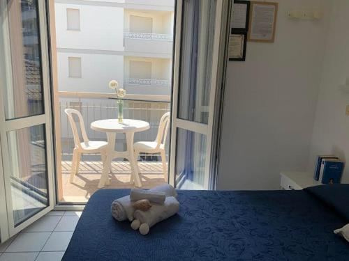 ein Teddybär auf einem Bett im Schlafzimmer in der Unterkunft HOTEL LA PERGOLA in Cattolica