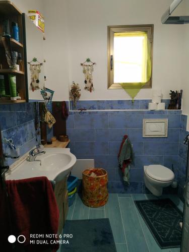 a bathroom with a sink and a toilet at Affittacamere Cooperativa Olistica in Mamoiada