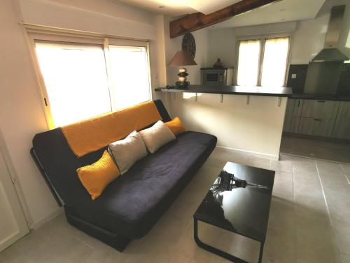 Murato的住宿－Maison de village proche commodités，客厅配有黑色沙发和桌子