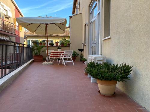 a patio with an umbrella and a table and chairs at mineVaganti in Ancona