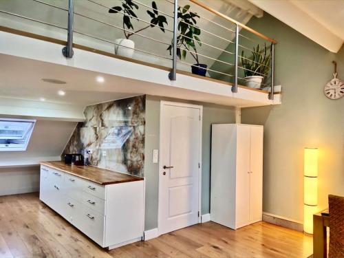 een keuken met een witte kast en een loft bij Peaceful home close to Airport with parking in Steenokkerzeel
