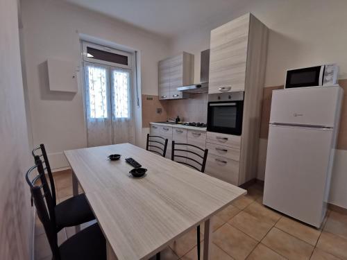 uma cozinha com uma mesa e um frigorífico branco em HappyHome, Belissimo appartamento in Torino em Turim