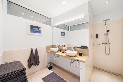 a bathroom with two sinks and a shower at Apartment near Volksoper - Modern, Big, Central, Cosy in Vienna
