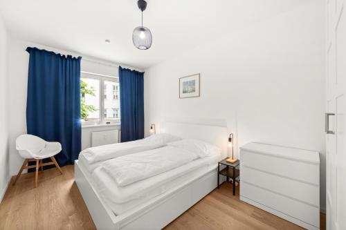 a bedroom with a white bed and blue curtains at Apartment near Volksoper - Modern, Big, Central, Cosy in Vienna