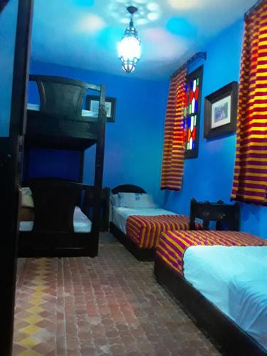 a bedroom with two bunk beds and blue walls at Dar Lbakal in Chefchaouene