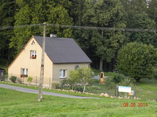 a small house with a black roof on a road at Zgorzanka in Istebna