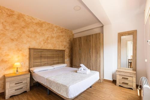 a bedroom with a large bed and a mirror at GTCS Mendoza in Málaga