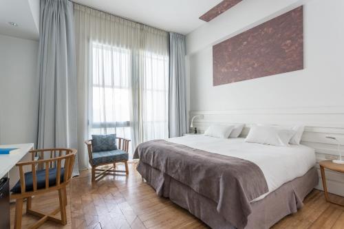 a bedroom with a bed and a desk and a chair at Hotel BA Jardines Palermo in Buenos Aires