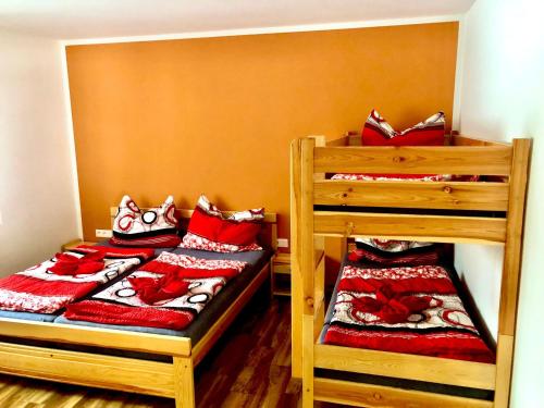 een slaapkamer met 2 stapelbedden met rode kussens bij Apartmán Lomňanka in Dolní Lomná