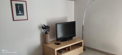 a television sitting on a wooden stand in a room at Apartment Višnja in Vodice