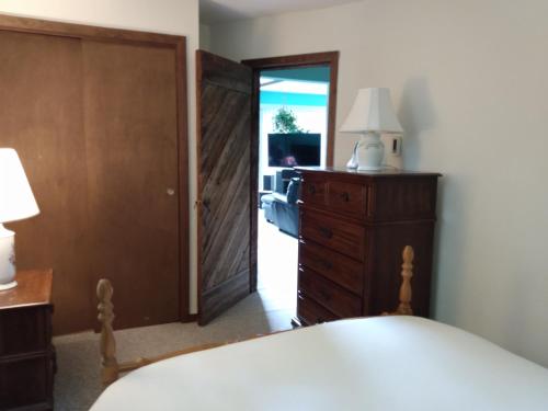 a bedroom with a bed and a dresser and a door at Mountain Retreat in Wilmington