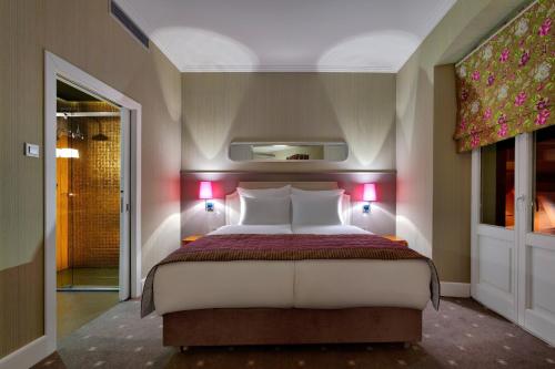 a bedroom with a large bed with red lights at Bristol Art & Medical SPA in Busko-Zdrój