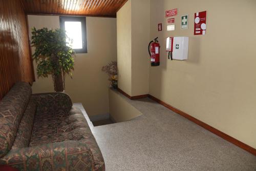 a waiting room with a couch and a fire hydrant on the wall at SOFT ROOMS in Vila Real