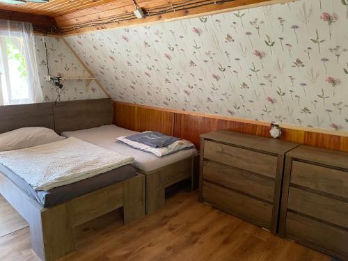 a small room with two beds and a wall with flowers at Chata Dagmar in Třebíč