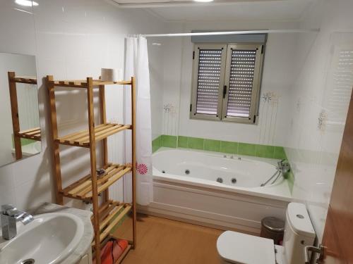 a bathroom with a tub and a toilet and a sink at LA MANCHEGUITA DE MADRIGUERAS 5 DORMITORIOS DOBLES CHALET CON PISCINA Y BARBACOA ideal familias 11 personas 