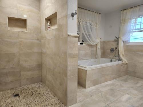 y baño con bañera y ducha. en Bermuda Connections Guest House en Southampton