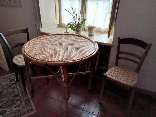 uma mesa e cadeiras num quarto com uma janela em Il Giardino dei Merli em Bussoleno