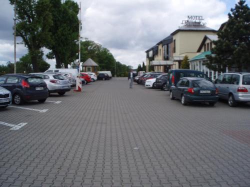 a street with cars parked in a parking lot at Motel Paradise in Torzym