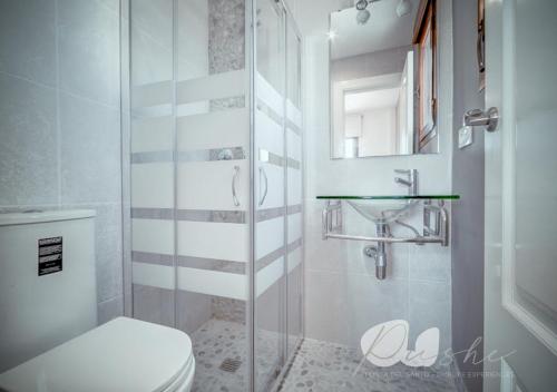 a bathroom with a toilet and a glass shower at PUSHE Village Playa Granada Beach&Golf 2 in Motril