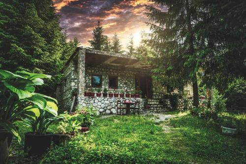 uma pequena casa de pedra no meio de um quintal em Guest house Hyrmet Demushi em Valbonë