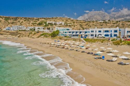 una playa con sillas y sombrillas y el océano en Aegean View Studios en Lefkos Karpathou